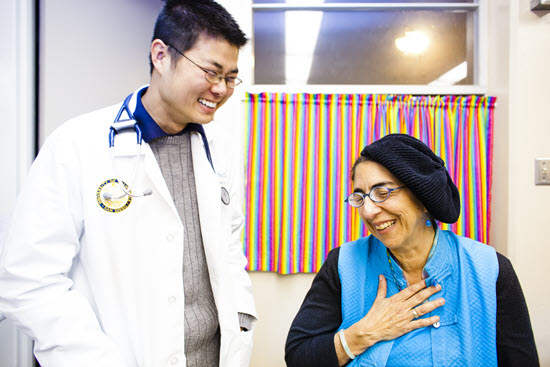 physician standing next to smiling patient