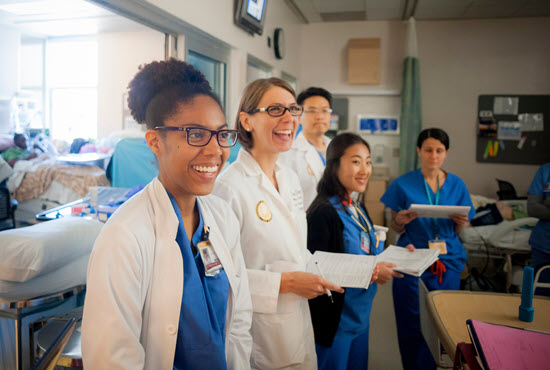 group of smiling residents observing a patient in the hospital 