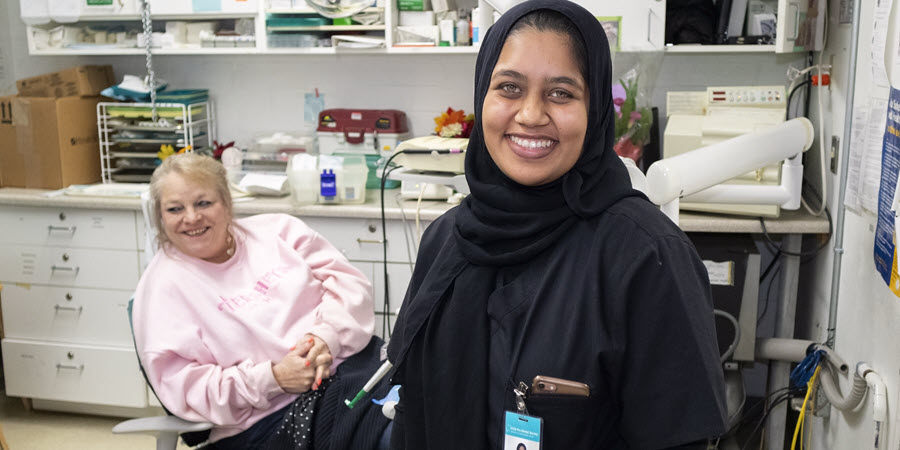 volunteer stands in front of patient in dental chair